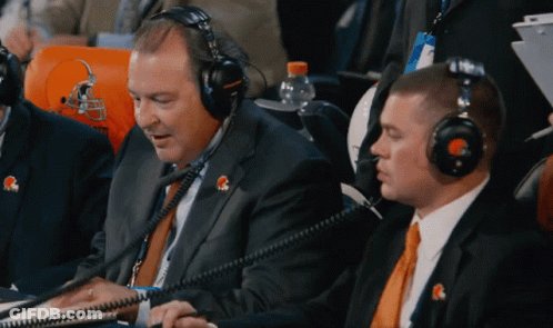 A Man Wearing A Headset With A Cleveland Browns Logo On His Shirt GIF