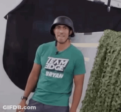 A Man Wearing A Helmet And A Green Team Edge T-Shirt . GIF