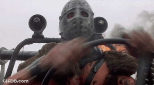 A Man Wearing A Helmet And A Mask Is Driving A Car GIF