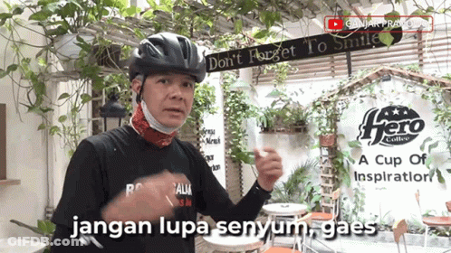 A Man Wearing A Helmet And A Mask Stands In Front Of A Sign That Says Hero Coffee GIF