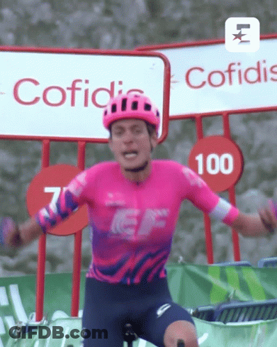 A Man Wearing A Helmet And A Pink Shirt With The Number 100 On It GIF