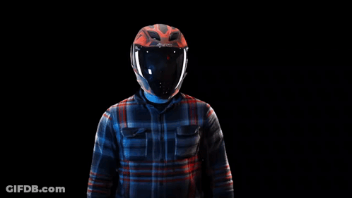 A Man Wearing A Helmet And A Plaid Shirt Is Standing In Front Of A Black Background . GIF