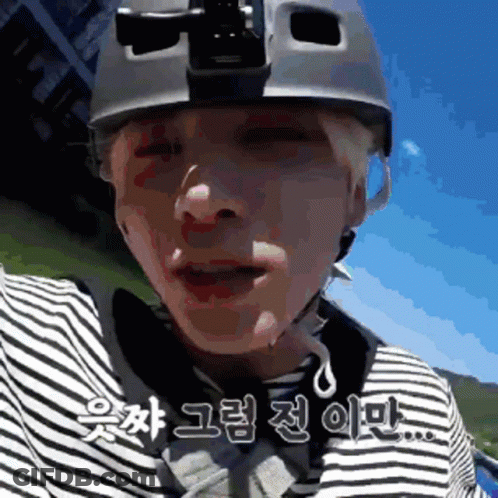 A Man Wearing A Helmet And A Striped Shirt Is Talking In Korean GIF