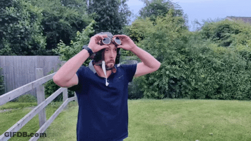 A Man Wearing A Helmet And Goggles In A Yard GIF