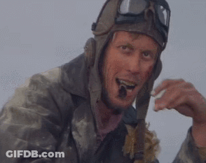 A Man Wearing A Helmet And Goggles Is Eating A Piece Of Bread . GIF
