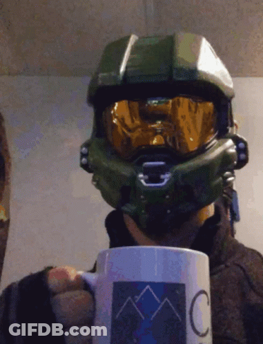 A Man Wearing A Helmet And Goggles Is Holding A Mug That Says C On It GIF