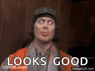 A Man Wearing A Helmet And Goggles Is Making A Funny Face And Says `` Looks Good '' . GIF