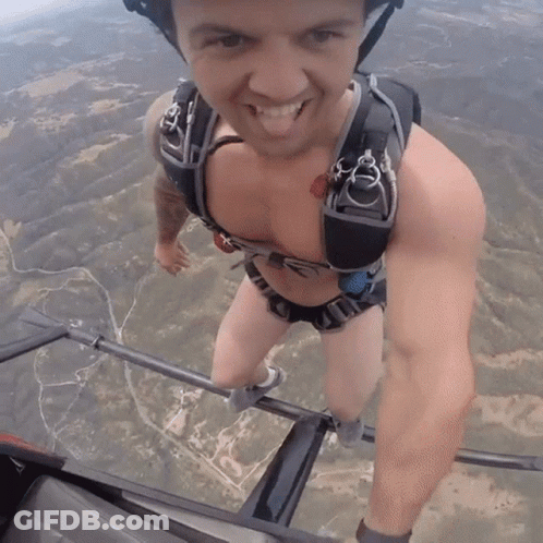 A Man Wearing A Helmet And Parachute Is Smiling GIF