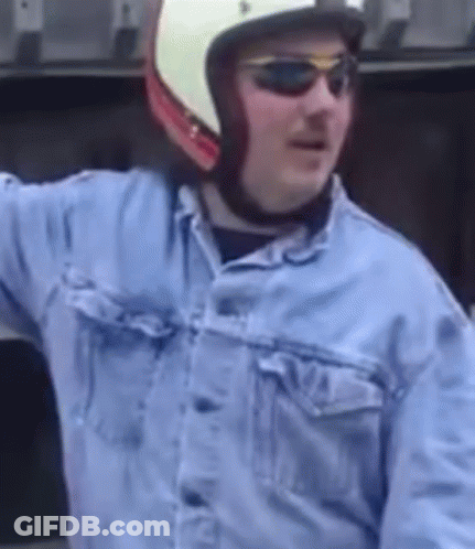 A Man Wearing A Helmet And Sunglasses Is Wearing A Denim Jacket GIF