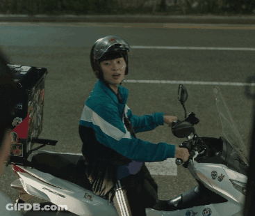A Man Wearing A Helmet Is Riding A Motorcycle With A Box On The Back Of It GIF