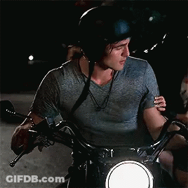 A Man Wearing A Helmet Is Riding A Motorcycle With A Woman Hugging Him . GIF