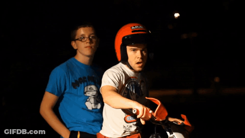 A Man Wearing A Helmet Is Sitting On A Dirt Bike Next To Another Man GIF