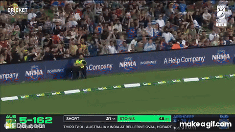 A Man Wearing A Helmet Stands In Front Of A Screen That Says Cricket On It GIF