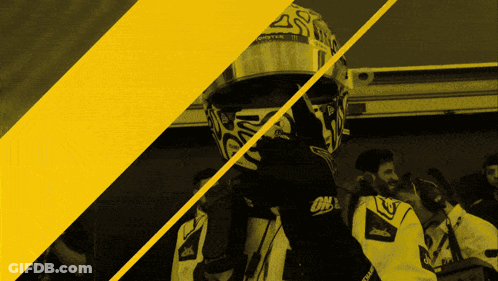 A Man Wearing A Helmet That Says Monster Is Standing Next To Another Man GIF