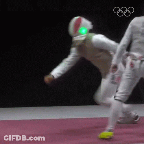 A Man Wearing A Helmet With A Green Light On It Is Playing Fencing Against Another Man . GIF