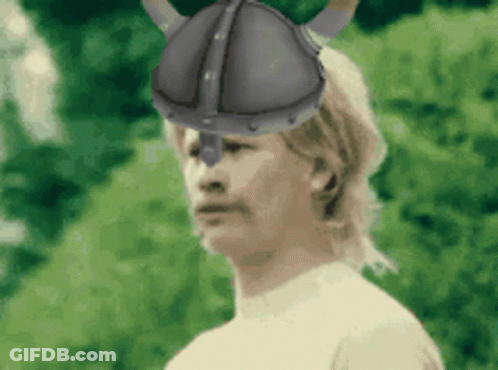 A Man Wearing A Helmet With Horns On It GIF