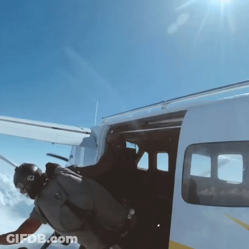 A Man Wearing A Helmet With The Letter B On It Is Getting Out Of A Plane GIF