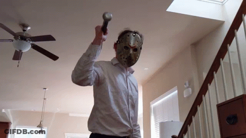 A Man Wearing A Hockey Mask Holds A Microphone GIF