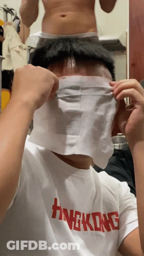 A Man Wearing A Hong Kong T-Shirt Covers His Face With A Piece Of Paper GIF