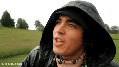 A Man Wearing A Hooded Jacket And A Scarf With A Native American Design On It GIF