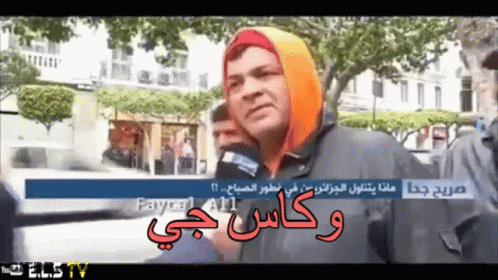 A Man Wearing A Hooded Jacket Talks Into A Microphone While Being Interviewed By A Youtube Channel Called Elstv GIF