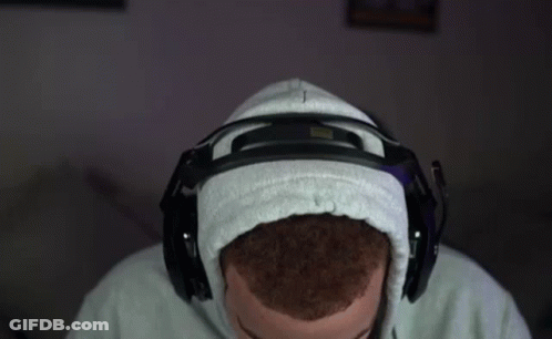 A Man Wearing A Hoodie And Headphones Is Sitting In Front Of A Computer . GIF