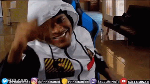 A Man Wearing A Hoodie Is Smiling In Front Of A Screen That Says Princetatted On It GIF