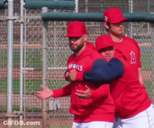 A Man Wearing A Hoodie That Says Angels On It Is Hugging Another Man GIF