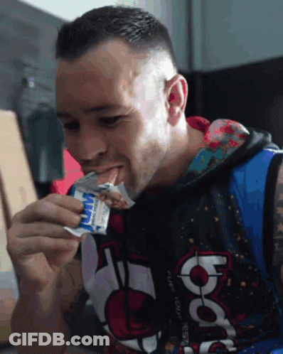 A Man Wearing A Hoodie That Says Nba Is Eating A Snack GIF