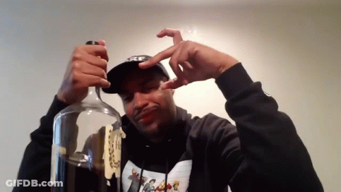A Man Wearing A Hoodie That Says ' Nike ' On It Is Opening A Bottle GIF