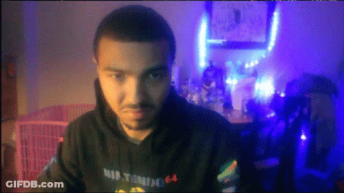 A Man Wearing A Hoodie That Says Nintendo 64 Looks At The Camera GIF