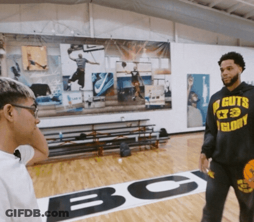 A Man Wearing A Hoodie That Says No Guts Glory Talks To Another Man GIF