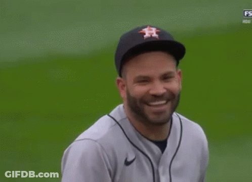 A Man Wearing A Houston Astros Baseball Jersey And Hat Is Smiling On A Baseball Field . GIF