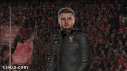 A Man Wearing A Jacket That Says Lfc Is Standing In Front Of A Crowd GIF