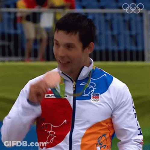 A Man Wearing A Jacket With The Word Czech On It Is Holding A Medal GIF