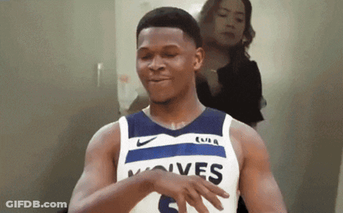 A Man Wearing A Jersey That Says Wolves Is Dancing GIF