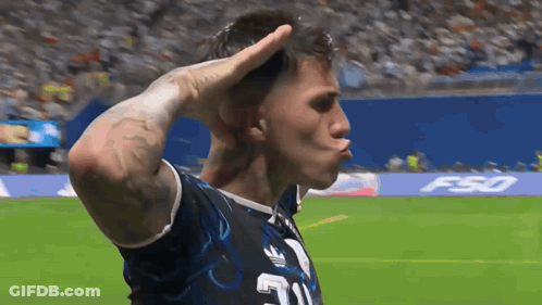 A Man Wearing A Jersey With The Number 21 On It Salutes On A Soccer Field GIF