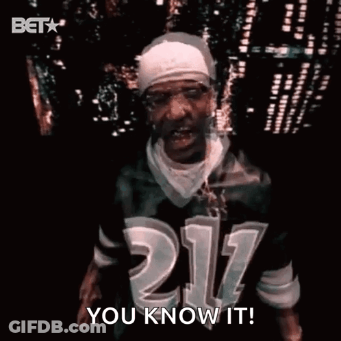 A Man Wearing A Jersey With The Number 211 On It Is Standing In Front Of A City Skyline At Night . GIF