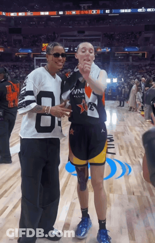 A Man Wearing A Jersey With The Number 8 On It Stands Next To Another Man GIF