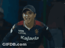A Man Wearing A Kajaria Jersey Holds Up His Arms GIF