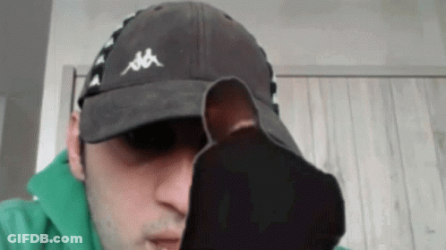 A Man Wearing A Kappa Hat Is Holding A Pair Of Socks In Front Of His Face GIF