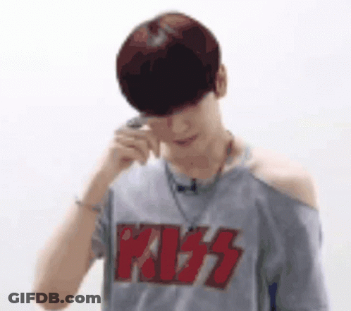 A Man Wearing A Kiss T-Shirt Is Talking On A Cell Phone . GIF
