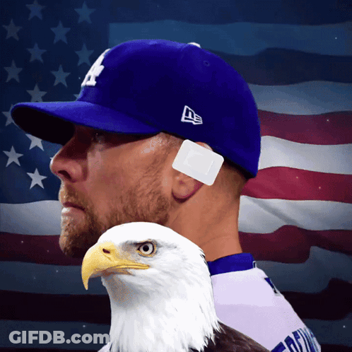 A Man Wearing A La Hat Holds A Bald Eagle In Front Of An American Flag GIF
