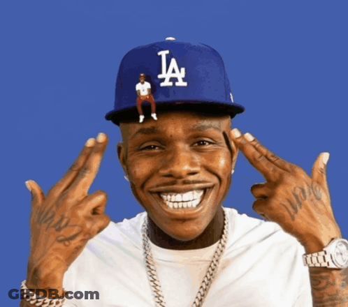A Man Wearing A La Hat Is Making A Funny Face GIF