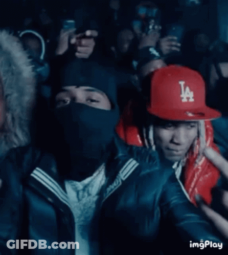 A Man Wearing A La Hat Is Pointing At Something GIF