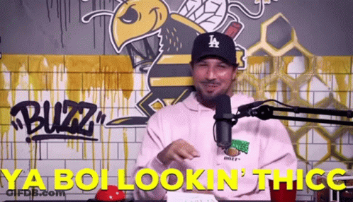 A Man Wearing A La Hat Is Standing In Front Of A Microphone And Says Ya Boi Lookin ' Thicc GIF