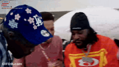 A Man Wearing A La Hat Is Standing Next To A Woman GIF
