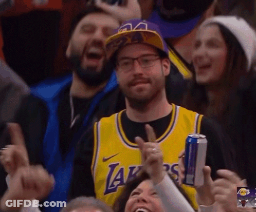 A Man Wearing A Lakers Jersey Is Holding A Can Of Red Bull GIF