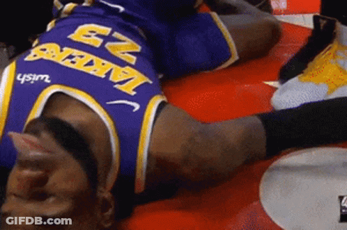 A Man Wearing A Lakers Jersey Is Laying On The Ground GIF