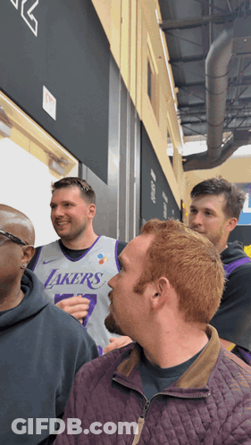 A Man Wearing A Lakers Jersey Stands In A Crowd Of People GIF
